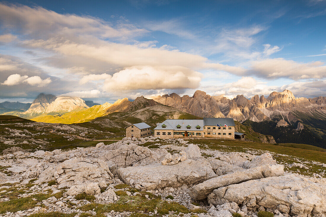 a wonderful sunset from the top of the Schlern, (Sciliar), with dolomites in the background and a beautiful hut in the foreground