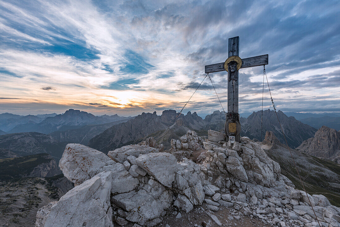 Sexten, Provinz Bozen, Dolomiten, Südtirol, Italien, Das Gipfelkreuz am Berg Paterno im Sonnenuntergang