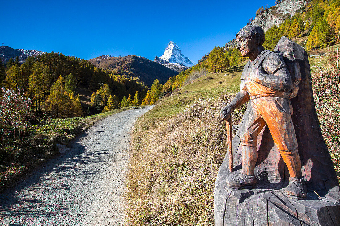 Hölzerne Statue mit einem Wanderer auf dem Weg zum Matterhorn Zermatt Kanton Wallis Schweiz Europa