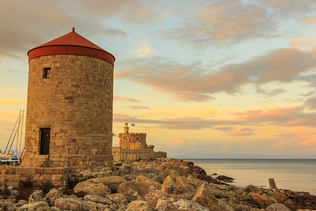 Mandraki Harbour mittelalterliche Windmühle und Festung bei Sonnenuntergang, Rhodos-Stadt, UNESCO-Weltkulturerbe, Rhodos, Dodekanes, griechische Inseln, Griechenland, Europa