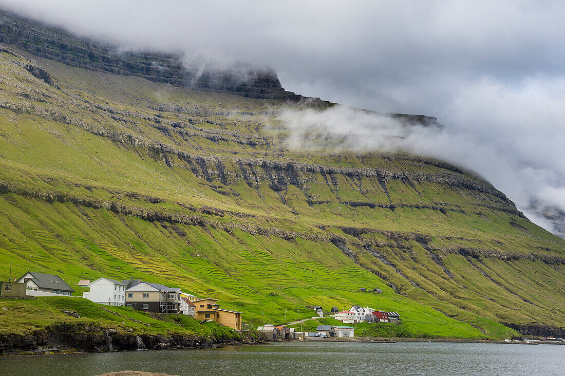 Little village below the cliffs of Kunoy, Faroe Islands, Denmark, Europe
