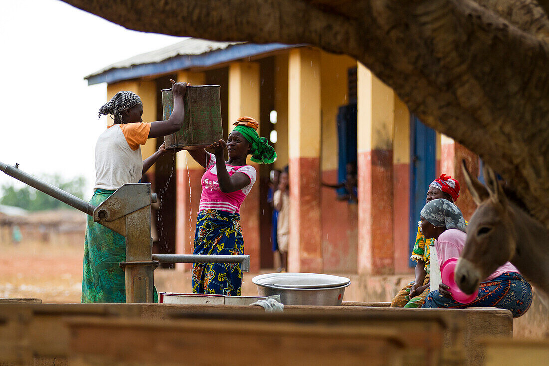 Women collecting water from one of the community water pumps in Tinguri, northern Ghana, West Africa, Africa