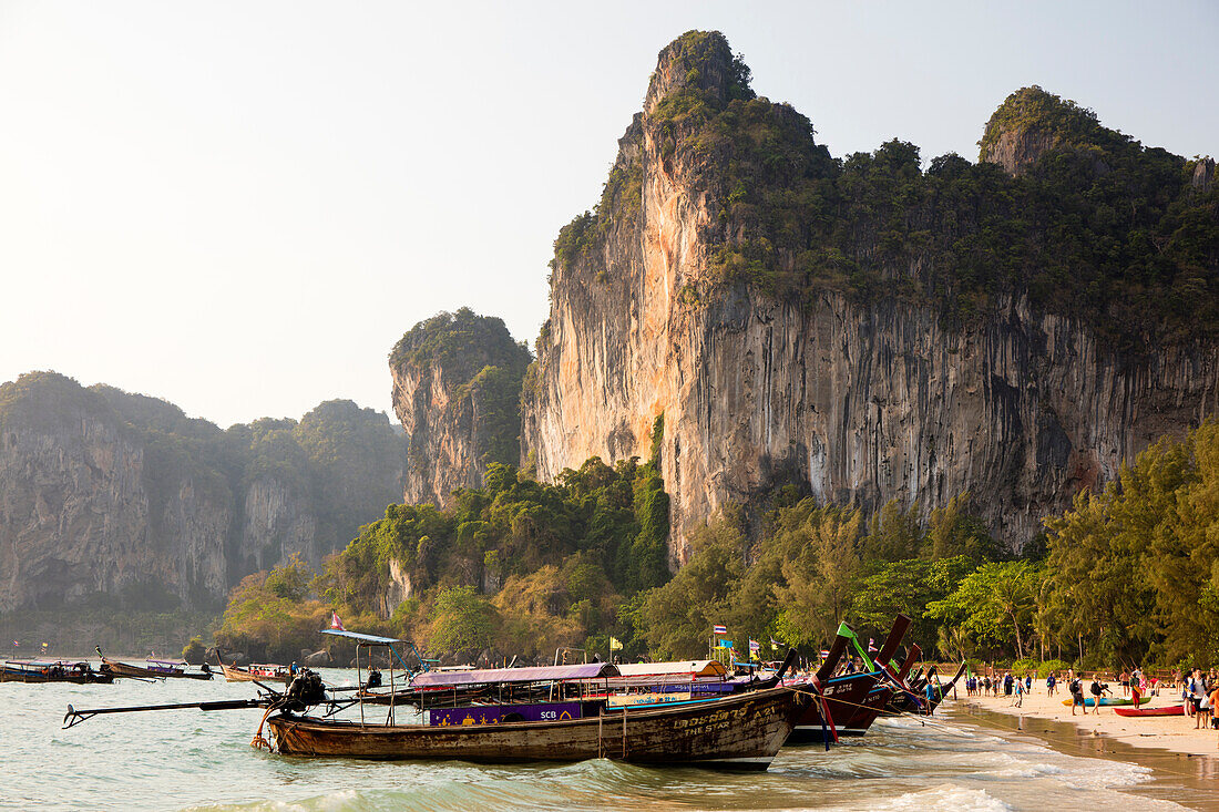 Traditionelle Longtail-Boote vertäut von Railay Beach mit Kalksteinfelsen im Hintergrund, Ao Nang, Krabi, Thailand, Südostasien, Asien