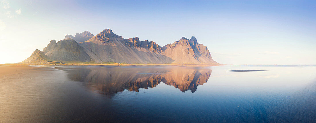 Panoramablick auf Vestrahorn Mountain Range spiegelt sich in seichten schwarzen Vulkanstrand, Stokksnes, Südisland, Polargebiete