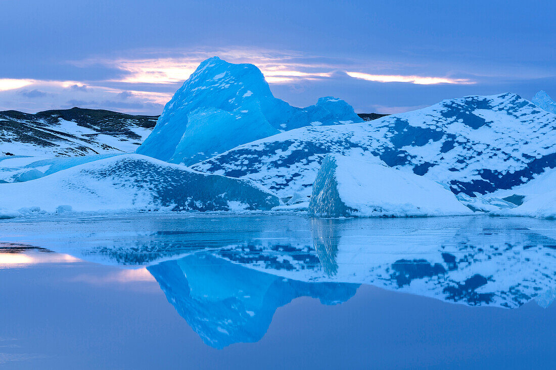 Icebergs covered in dusting of snow, winter, sunset, Jokulsarlon Glacial Lagoon, South Iceland, Polar Regions