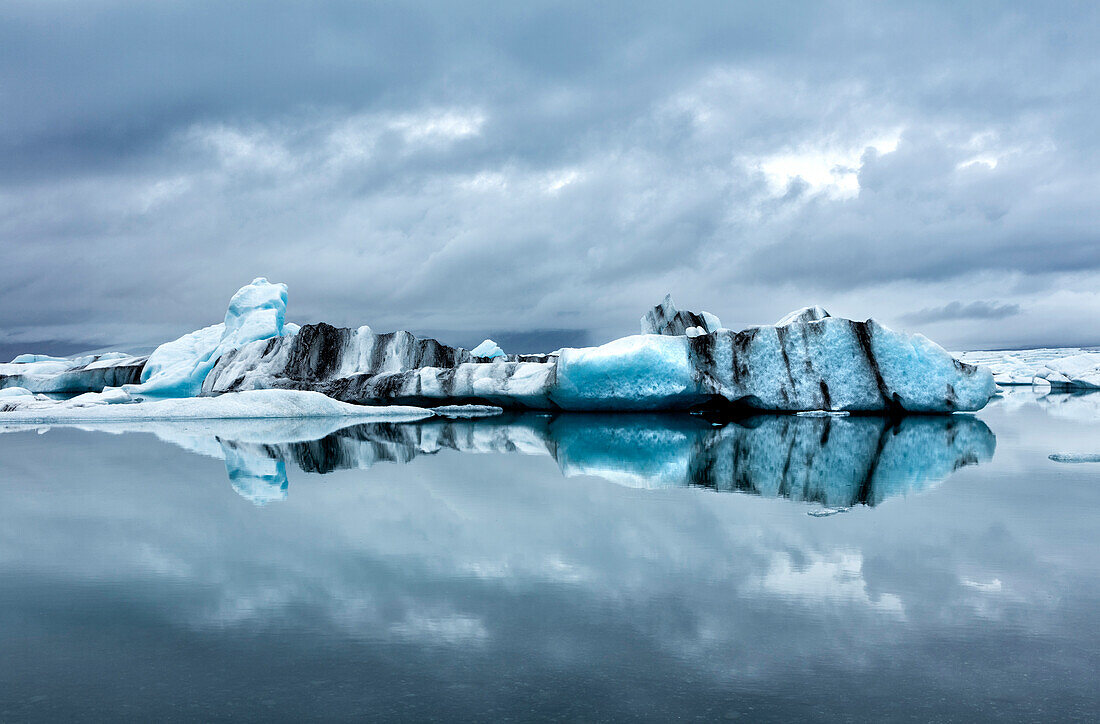 Eisberge und Reflexionen auf Gletscherlagune Jokulsarlon, Südisland, Polarregionen
