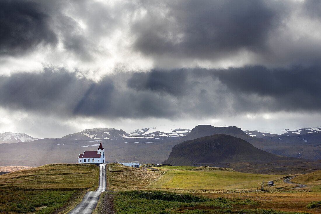 Ingjaldsholskirkja set against mountains on a dramatic stormy day, near Rif, Snaefellsnes Peninsula, Iceland, Polar Regions