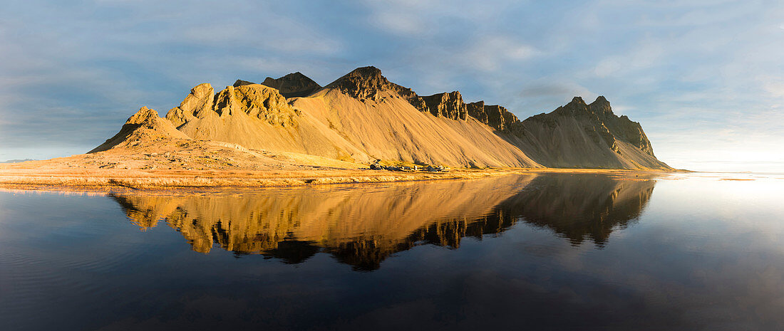 Panoramic view of mountains of Vestrahorn and perfect reflection in shallow water, soon after sunrise, Stokksnes, South Iceland, Polar Regions