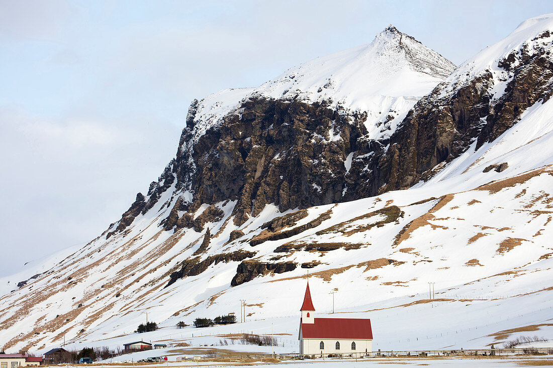 Rote und weiße Kirche gegen Schnee bedeckte Berge, Vik, Südisland, polare Regionen