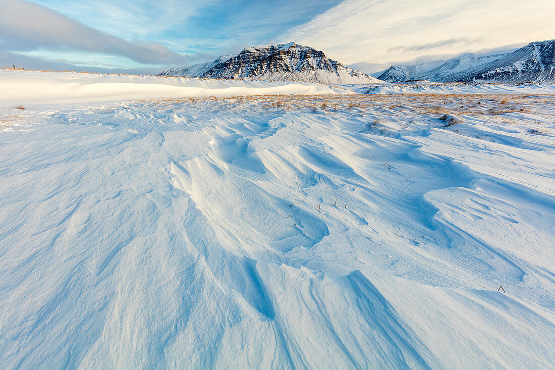 Atemberaubender Schnee bedeckte Winterlandschaft gebadet im Nachmittagssonnenlicht, auf der Straße zur Snaefellsnes-Halbinsel, Island, polare Regionen