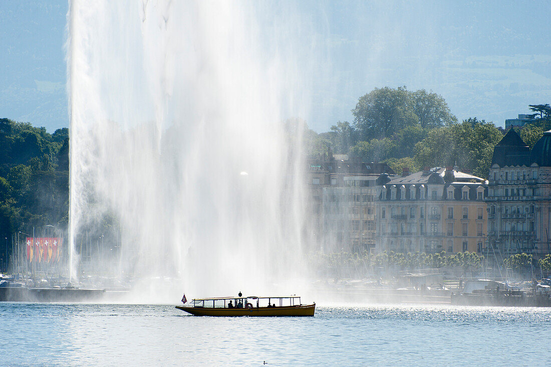 A water taxi passes by the Jet d'Eau at Lac Leman, Geneva, Switzerland, Europe