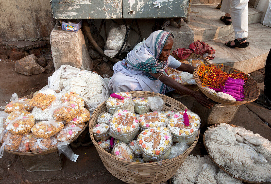 Woman in white sari, selling puja offerings from baskets in the street near the Hindu Jagannath temple dedicated to Lord Vishnu, Puri, Odisha, India, Asia
