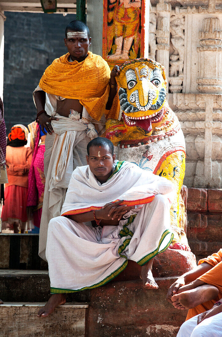 Hindu pilgrims in saffron and white robes, at the gate into Kapilash Temple ,Chandrashekhar Temple, Dhenkanal District, Odisha, India, Asia
