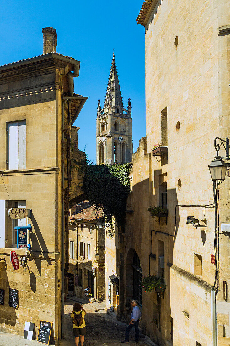 Schmale Rue de Girondins und die Kirche aus dem 13. Jahrhundert in dieser historischen Stadt und berühmten Bordeaux-Rotweingebiet, Saint Emilion, Gironde, Frankreich, Europa