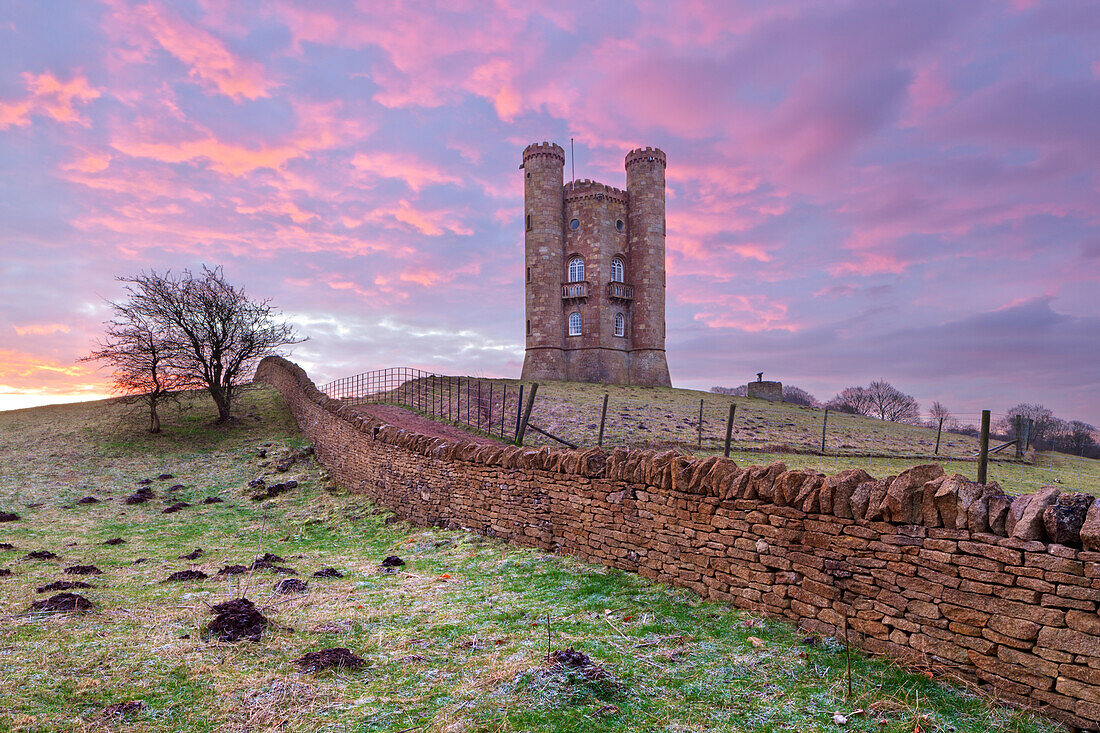 Broadway Tower und Cotswold Trockensteinmauer bei Sonnenaufgang, Broadway, Cotswolds, Worcestershire, England, Vereinigtes Königreich, Europa