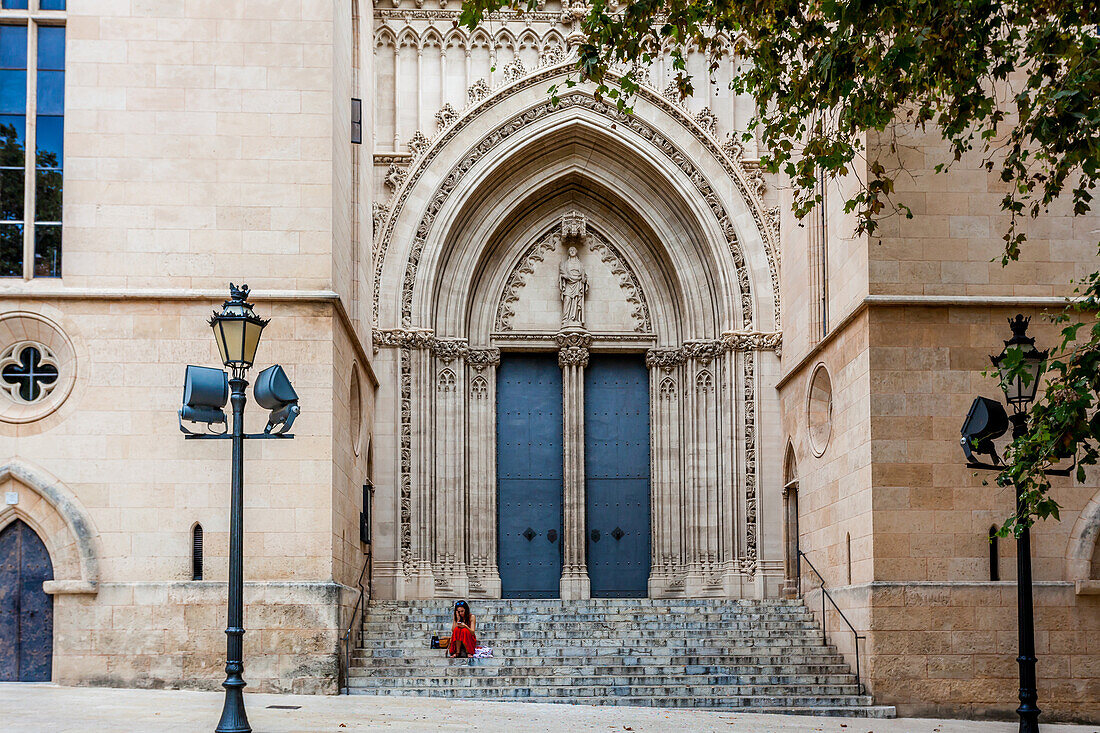 Frau in rotem Kleid auf der Treppe zu der Kirche Iglesia Santa Eulalia in der Altstadt von Palma, Ciutat Antiga, Palma de Mallorca, Majorca, Balearen, Balearische Inseln, Mittelmeer, Spanien, Europa
