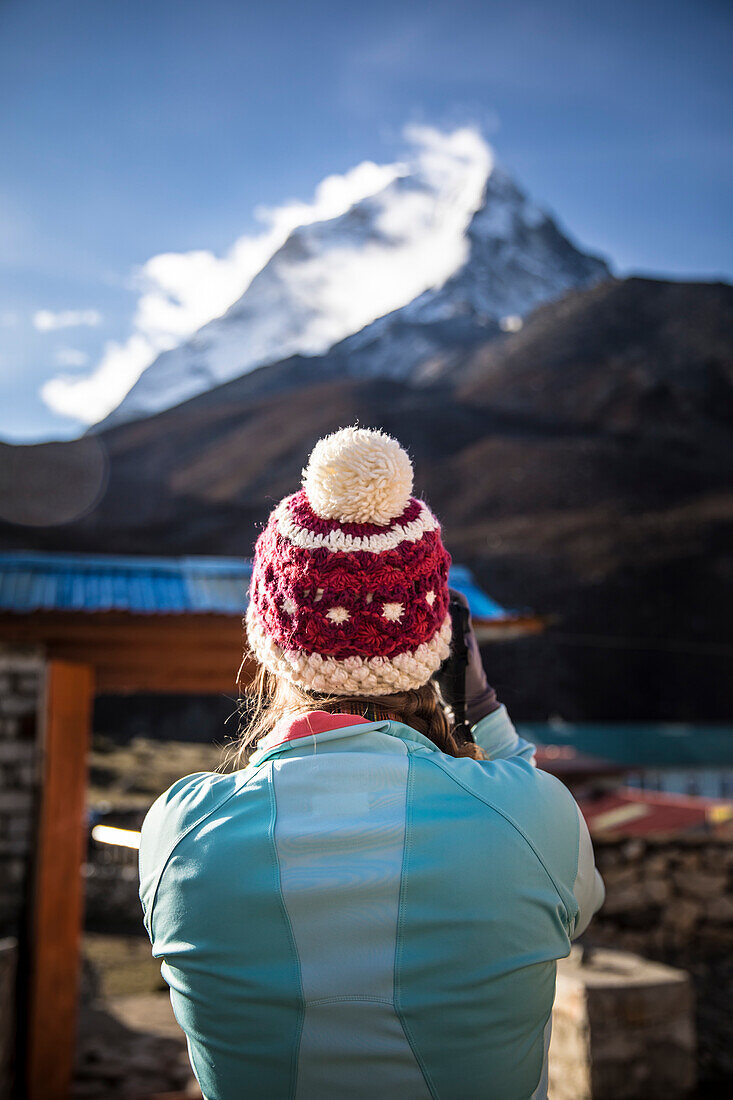 Hintere Ansicht der Frau im Knithut Ama Dablam Bergspitze von Himalaja, Dingboche, Khumbu, Nepal fotografierend