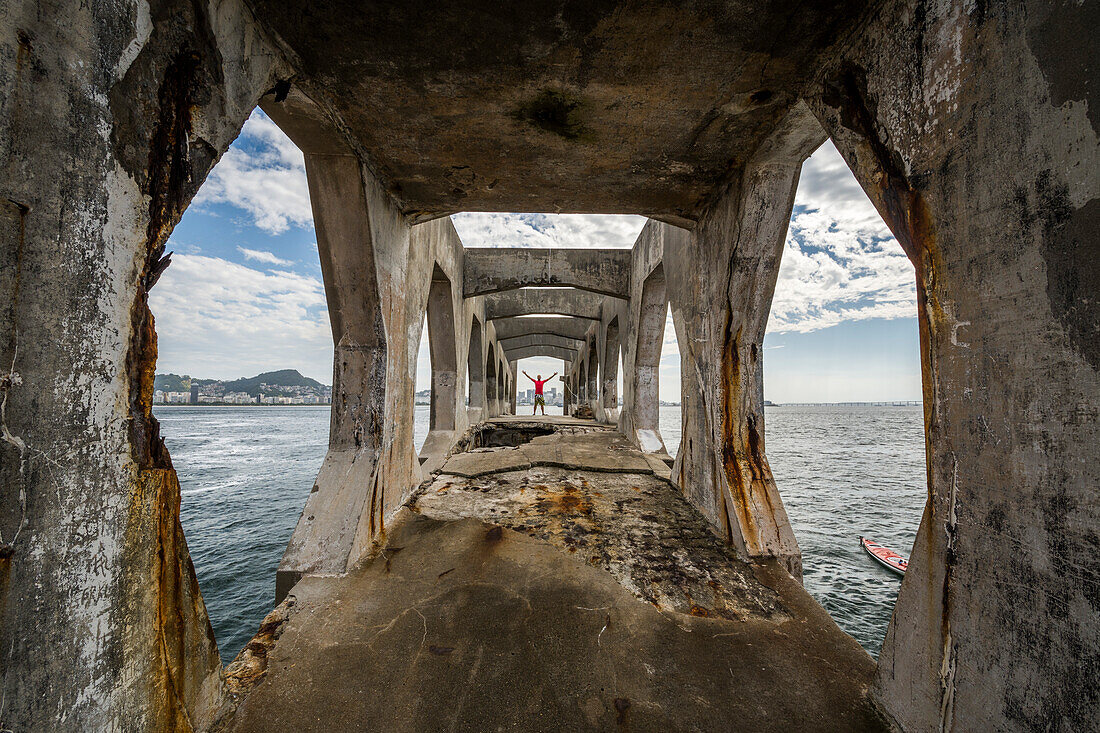 Man standing on edge of abandoned structure in Laje Fort in Guanabara Bay, Rio de Janeiro, Brazil