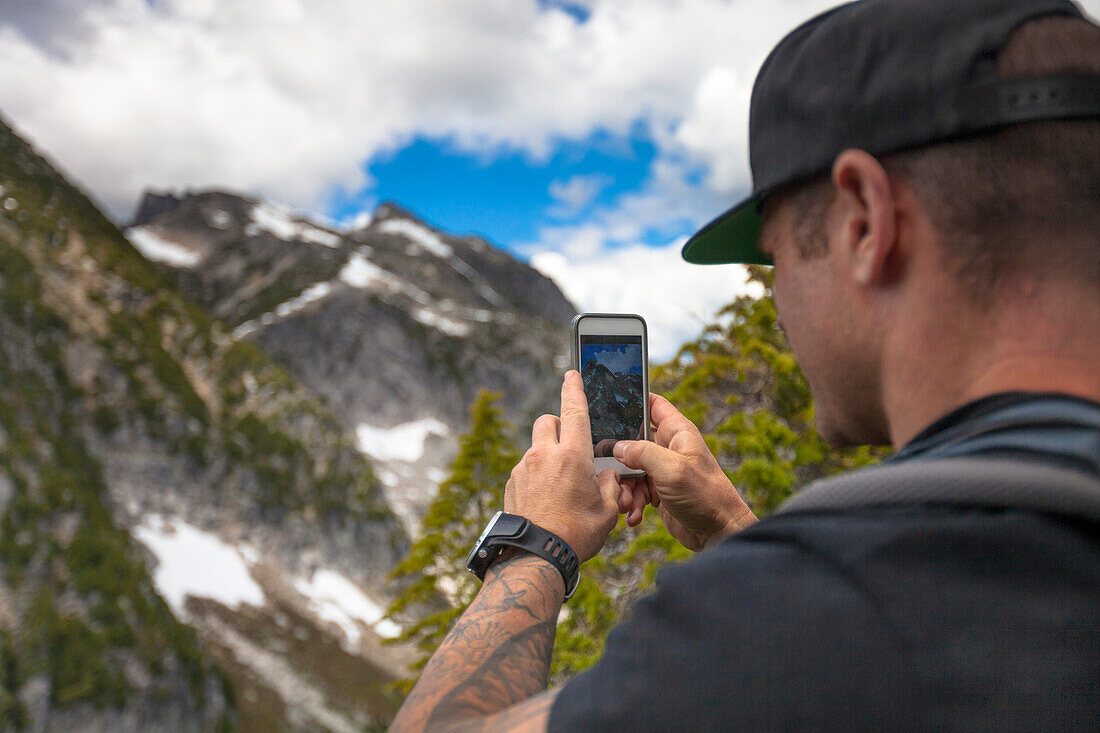 Bergsteiger, der Naturlandschaft mit Bergen unter Verwendung des Smartphone, Chilliwack, Britisch-Columbia, Kanada fotografiert