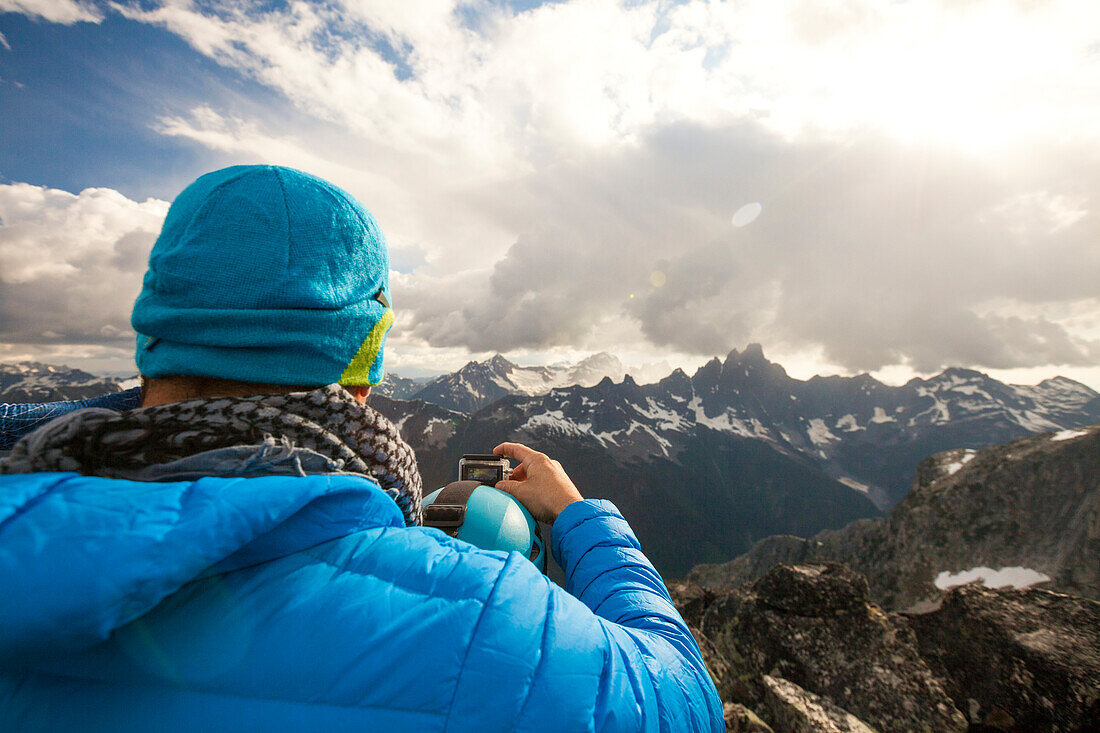 Über die Schulteransicht des Bergsteigers, der Foto von Slesse-Berg vom Gipfel des Bergs Rexford, Chilliwack, Britisch-Columbia, Kanada macht