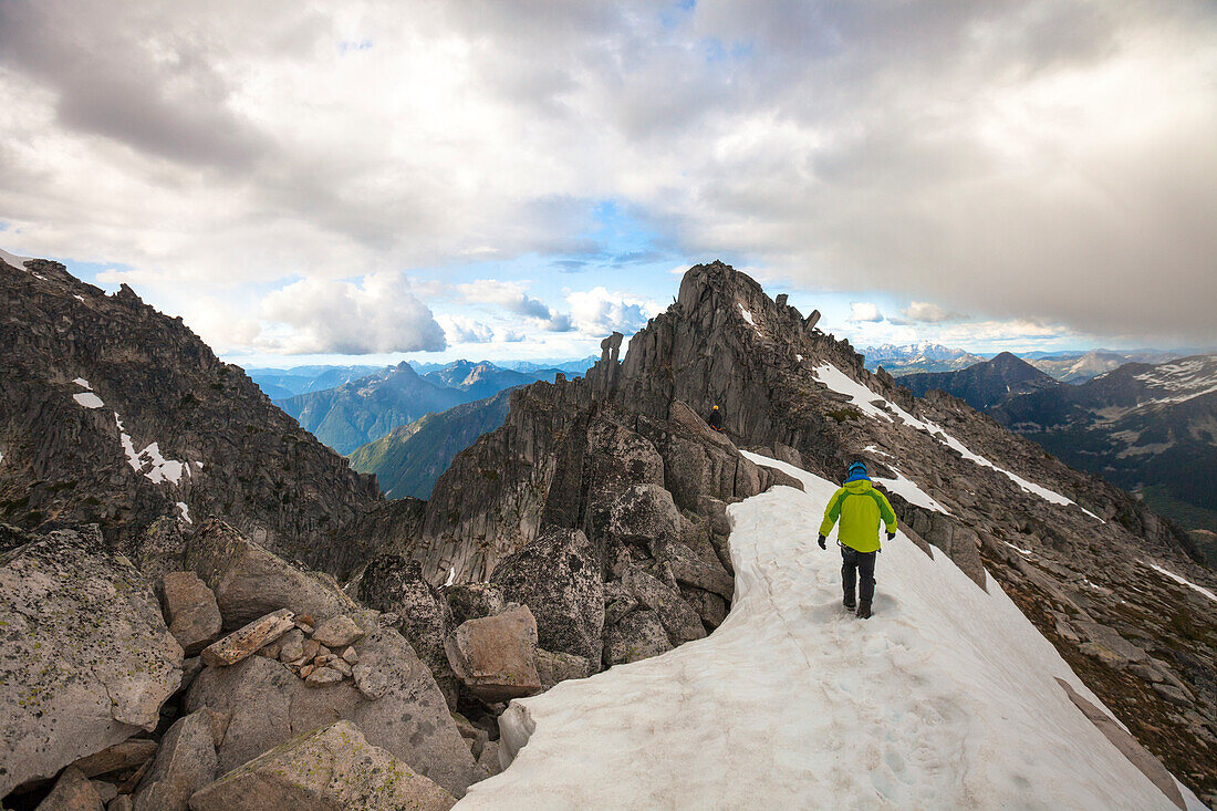 Photograph with rear view of mountain climber approaching south summit of Mount Rexford, Chilliwack, British Columbia, Canada