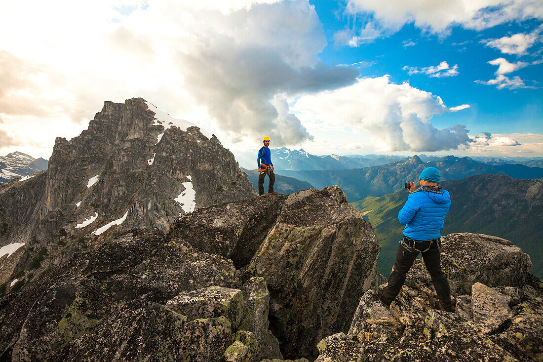 Mountaineer photographing another at summit of Mount Rexford, Chilliwack, British Columbia, Canada