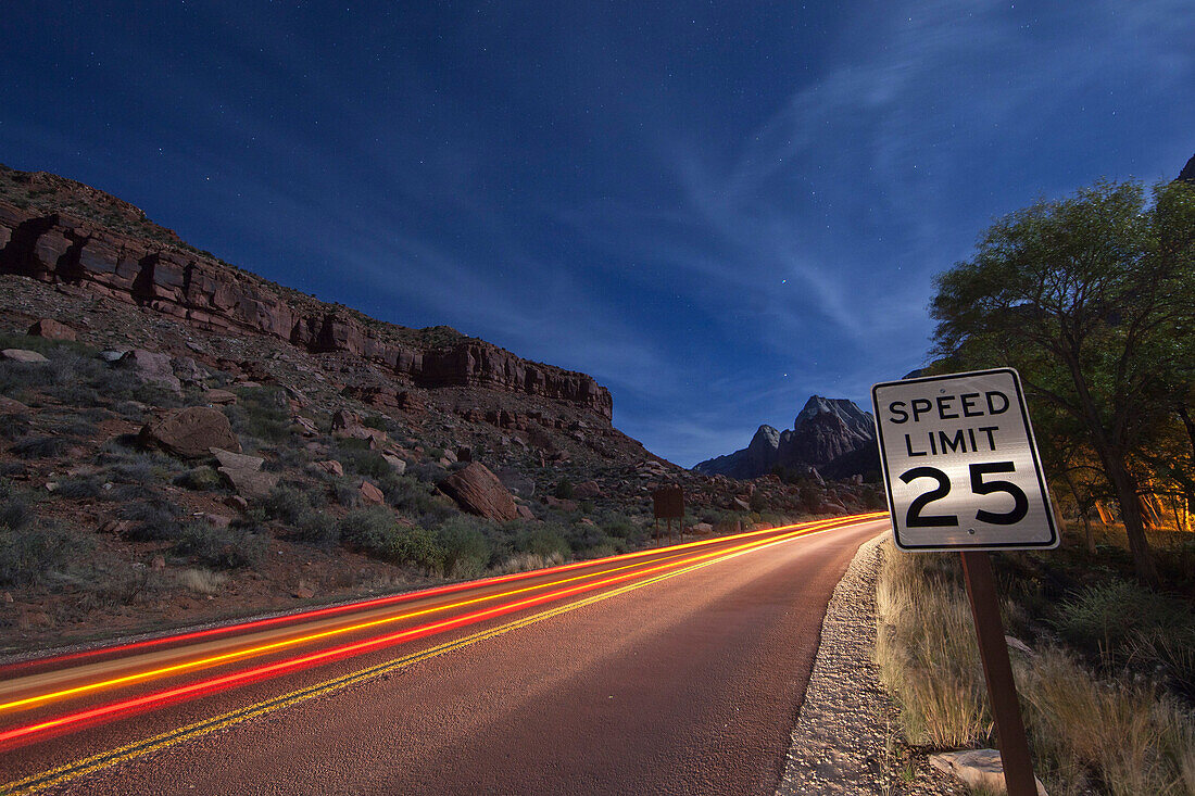 Ansicht von Lichtspuren auf Straße in der Wüste während der Nacht bei Zion National Park, Utah, USA.