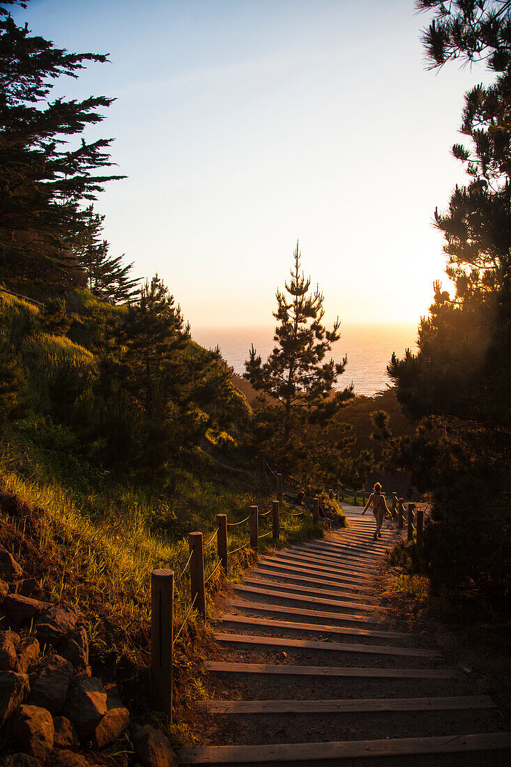Fotografie von den Schritten, die unten führen, um bei Lands End am Sonnenuntergang, San Francisco, Kalifornien, USA auf den Strand zu setzen.
