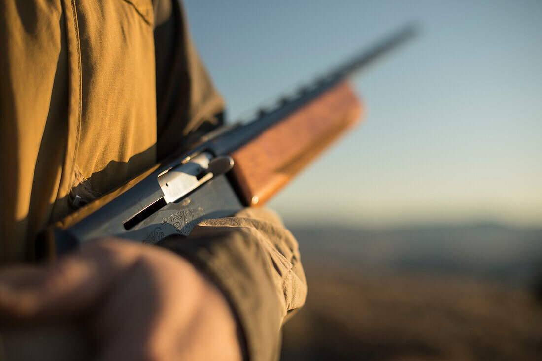 Hunter hält seine Schrotflinte auf der Jagd.