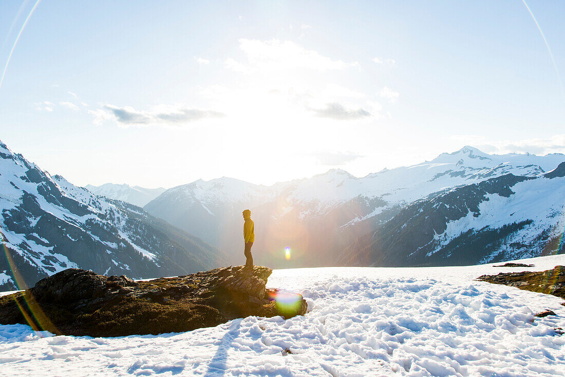 Seitenansichtphotographie des Mannes in der Winterjacke, die in den schneebedeckten Bergen an Sahale-Arm von Sahale-Spitze, Nordkaskaden-Nationalpark, Washington State, USA steht.