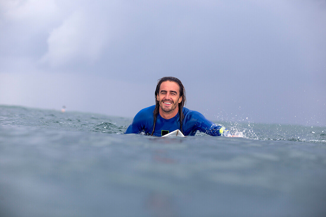 Surfer, der auf dem Meer schaufelt