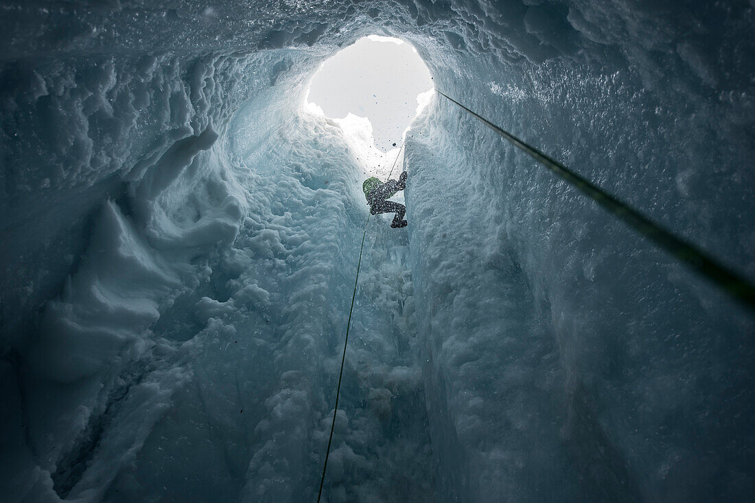 Photograph of adventurous man rappelling into moulin in Coleman Glacier, Mount Baker, Washington State, USA
