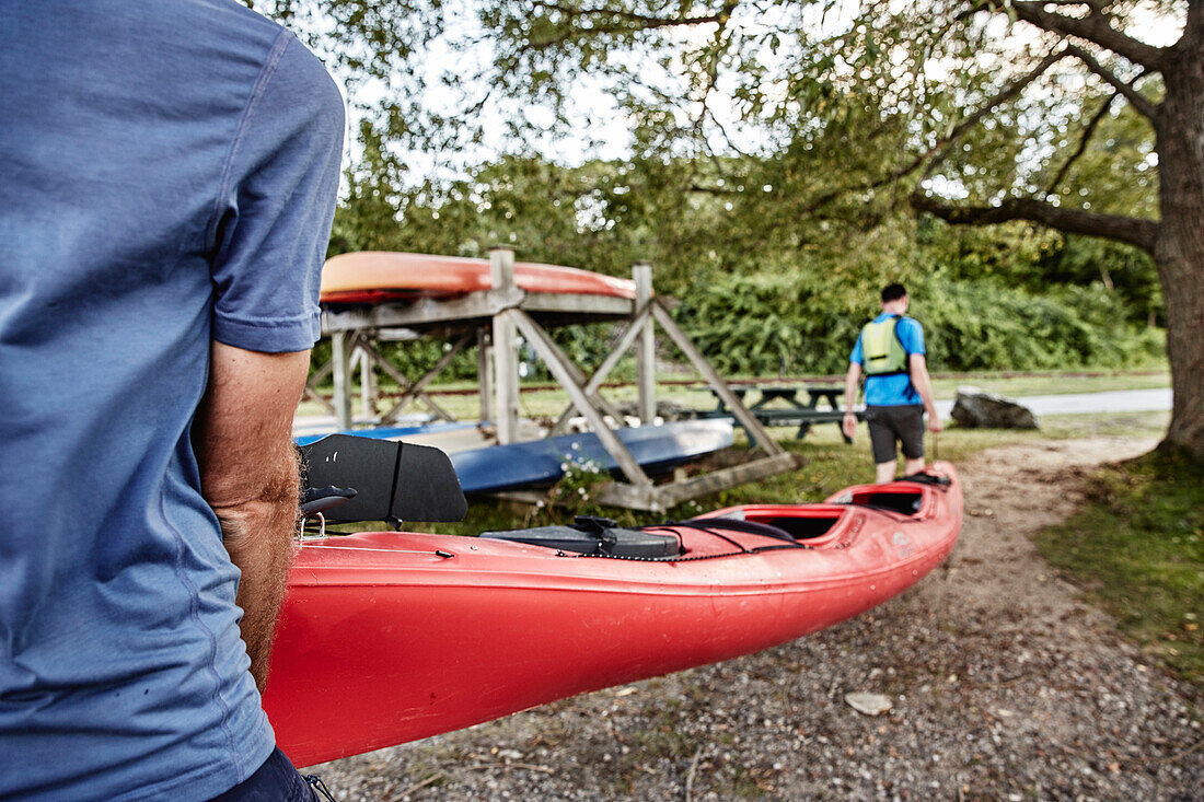 Photograph of two men carrying tandem sea kayak, Portland, Maine, USA