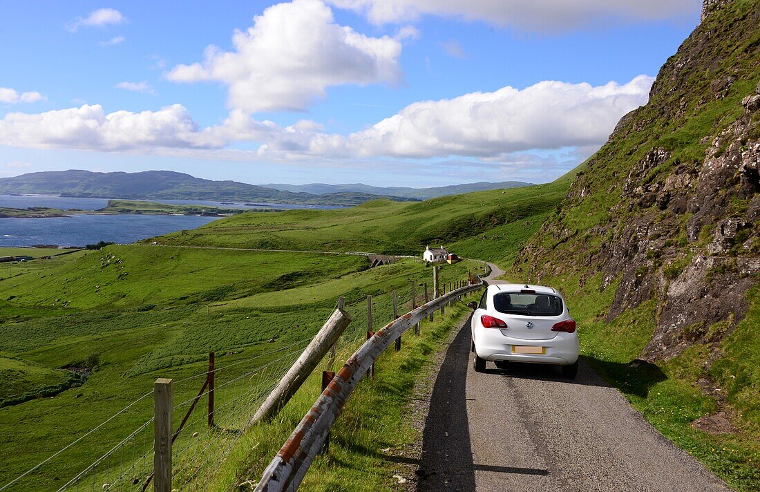 Auto auf kleiner Landstrasse an der Küste unter dem Ben More, Insel Mull, Schottland