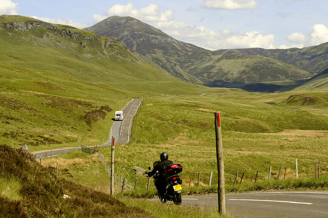 Motoradfahrer mit Landstrasse, Grampian Mountains in den Highlands, Schottland