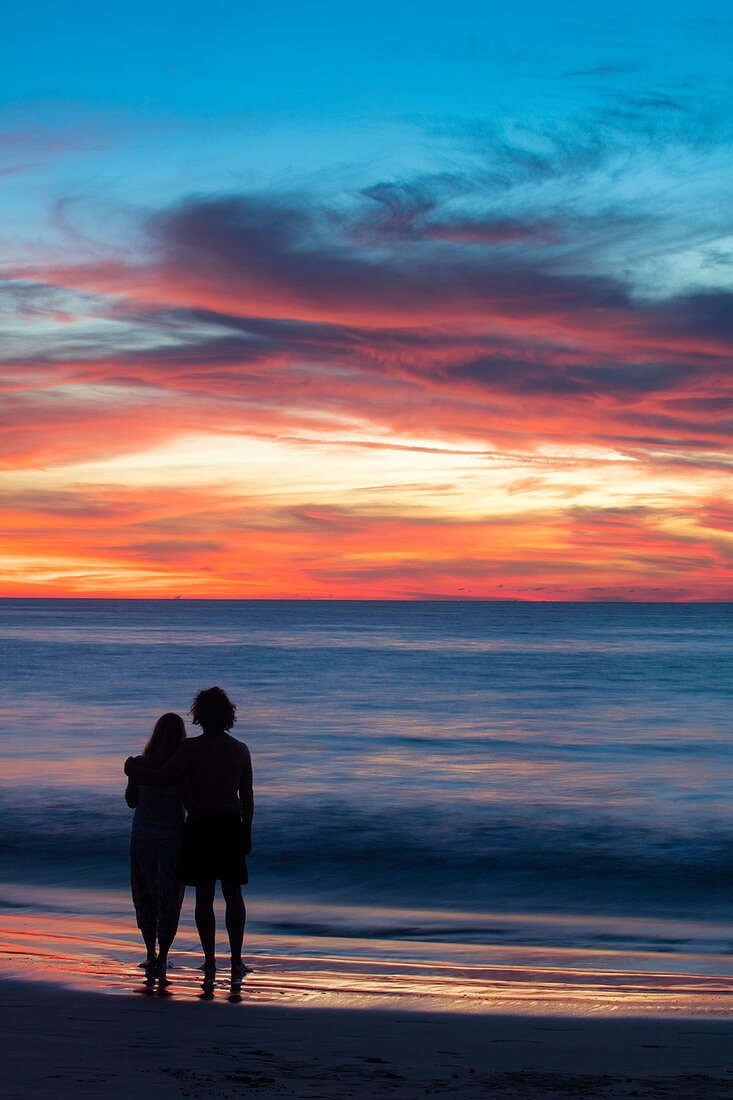 Silhouette of couple embracing at Ngapali Beach at sunset, Ngapali, Thandwe, Myanmar
