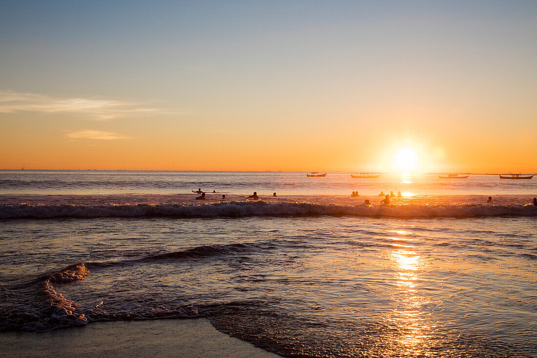 People swim and play in surf off Ngapali Beach at sunset, Ngapali, Thandwe, Myanmar