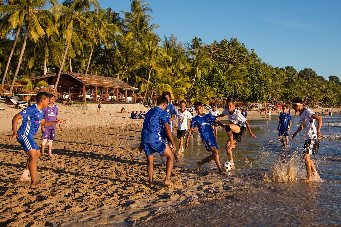 Young men play soccer during official league match on Ngapali beach, Ngapali, Thandwe, Myanmar