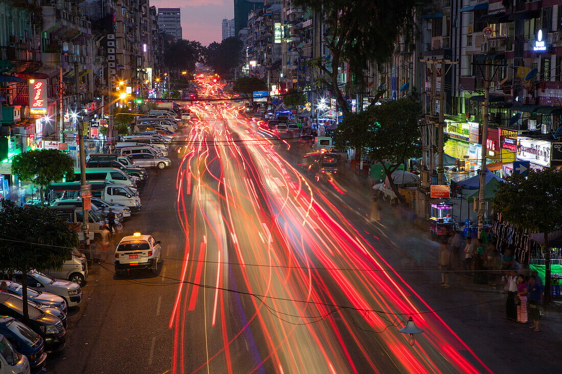 Langzeitbelichtung mit Lichtstreifen von Autos auf der Anawrahta Road in der Abenddämmerung, Yangon, Yangon, Myanmar
