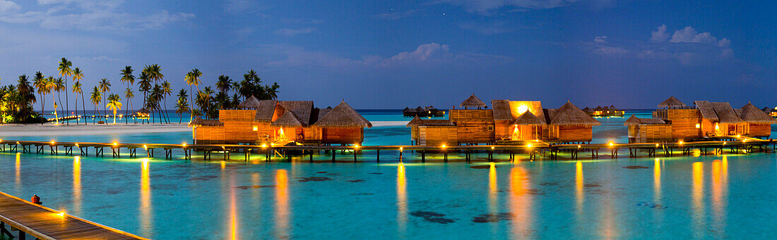 Luftaufnahme des tropischen Luxusresorts mit Pfahlbauten auf Gili Lankanfushi Insel bei Nacht