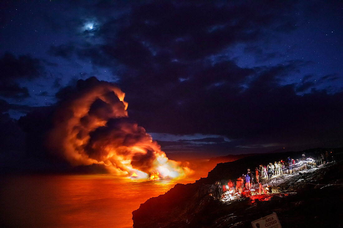Touristen, die Lava vom Kilauea-Vulkan betrachten, der in den Ozean bei Kamokuna gießt