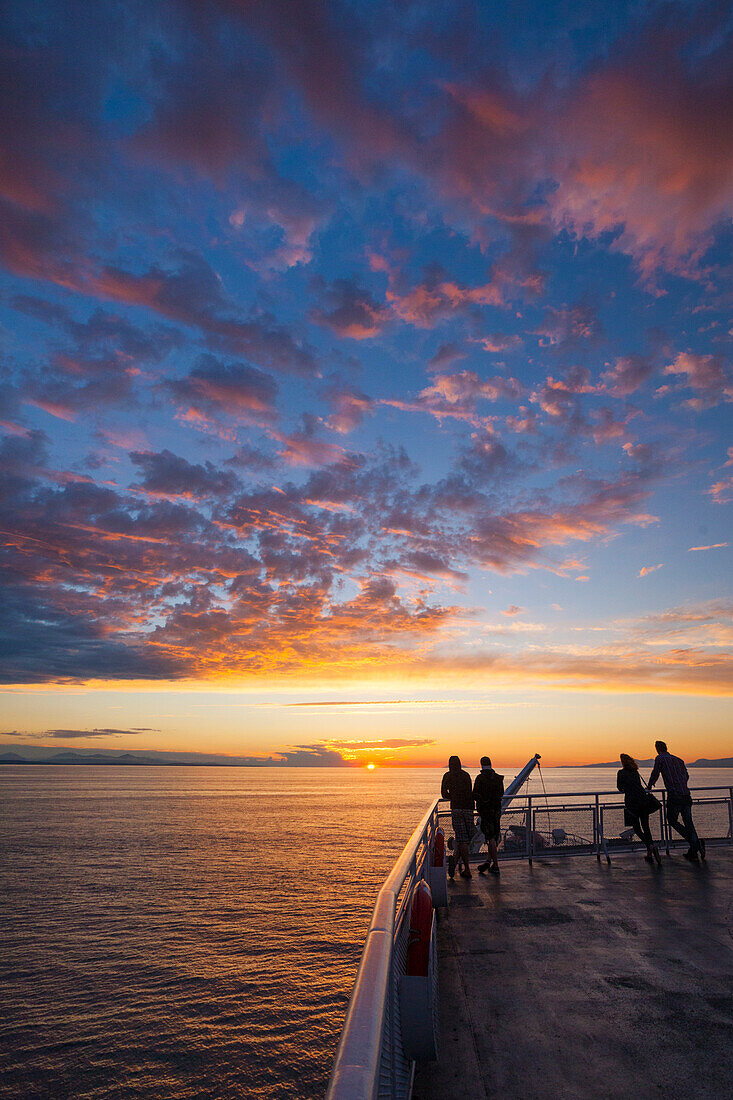 Silhouettierte Passagiere Uhren Der Sonnenuntergang von der Top-Deck eines Fährschiffs British Columbia