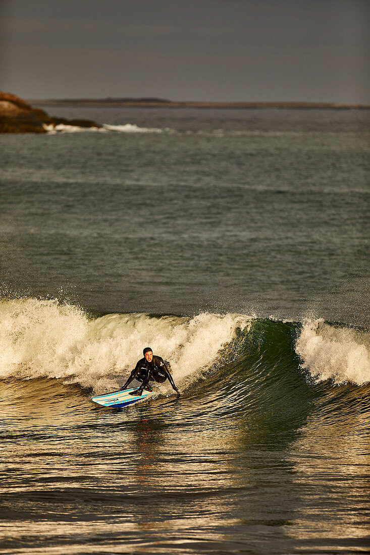 Ein Surfer, der auf Wellen am guten Hafen-Strand in Gloucester, Massachusetts surft