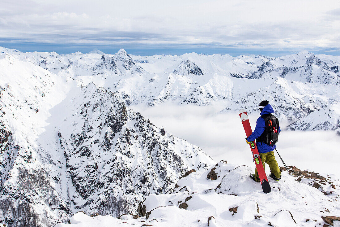 A skier stands on a ledge and explores the Andes of Cerro Catedral in Argentina