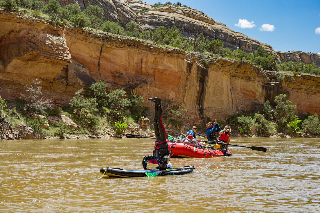 Man is making a headstand during a rafting trip on the Yampa and green rivers