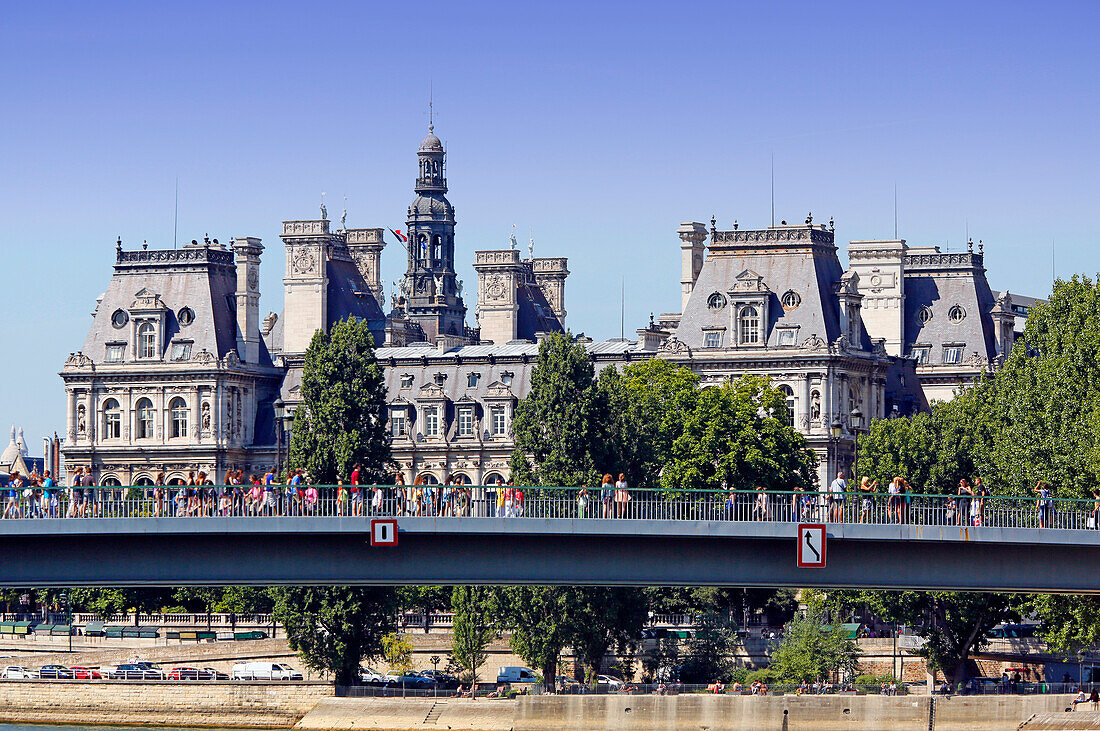 France, Paris, 4th arrondissement, facade of the Hotel de Ville (Seine side). In the foreground: the Saint Louis bridge, tourists on it