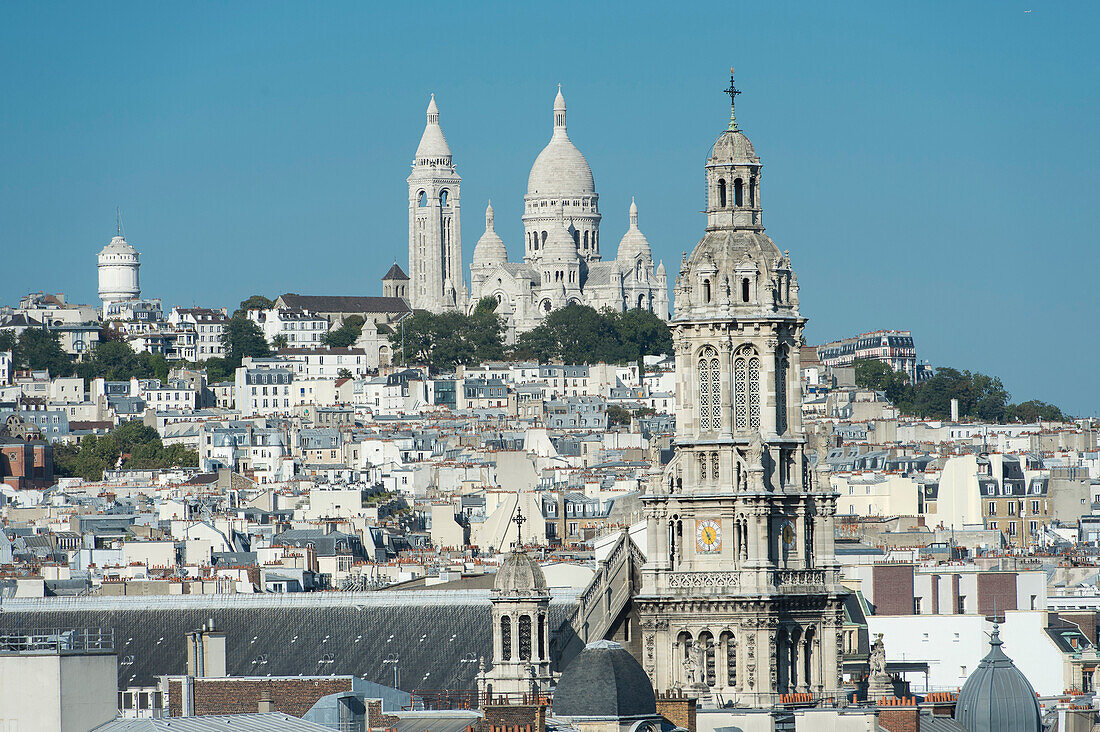 France. Paris 9th district. Bell tower of the Sainte Trinité church and the Sacre-Cœur Basilica