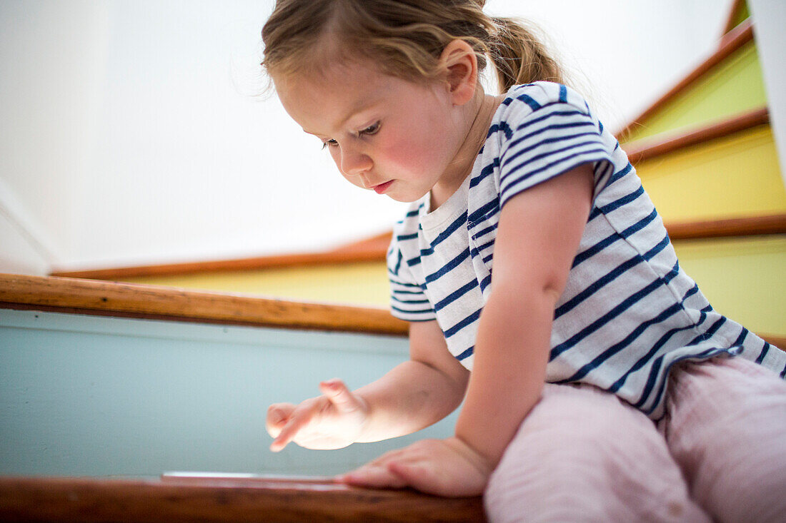 Caucasian girl using digital tablet on staircase
