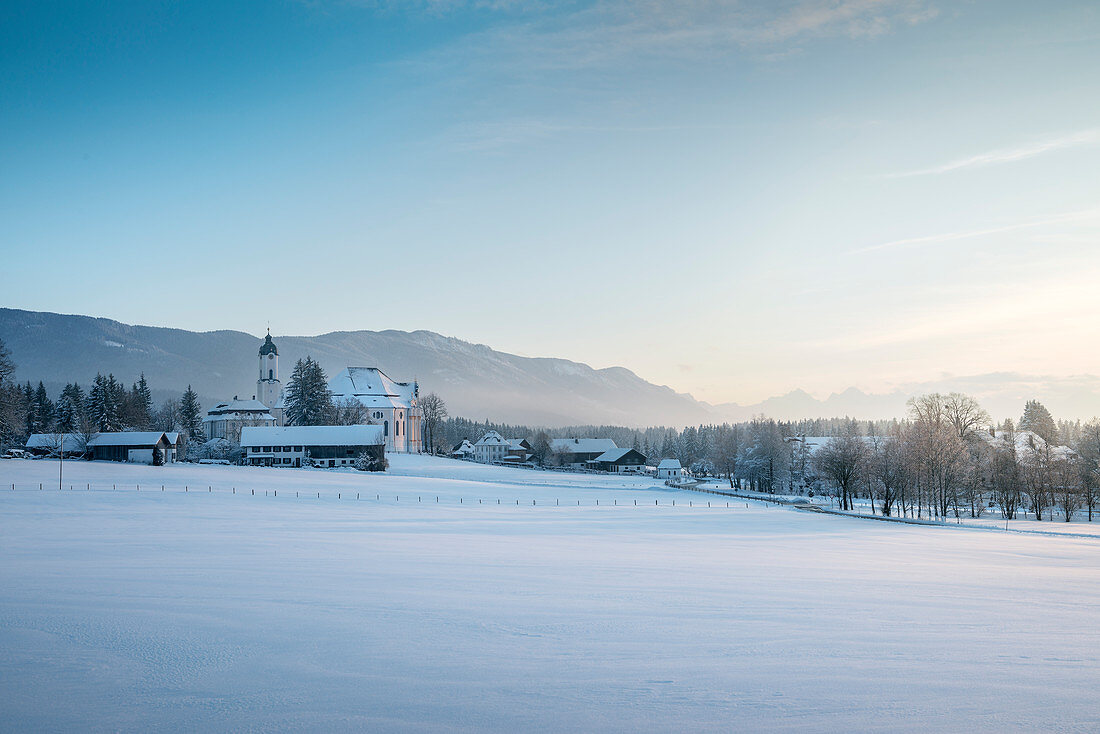 UNESCO World Heritage Wies Church, pilgrimage church surrounded by snow, view towards the Alps, Steingaden, Bavaria, Germany