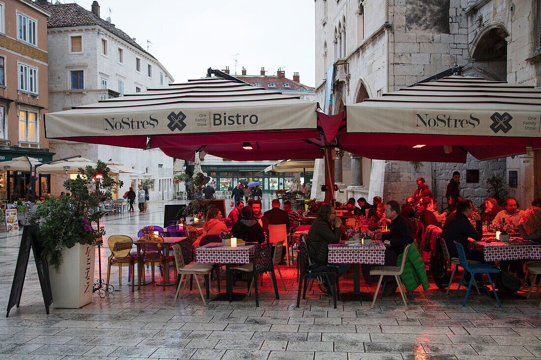 People sit underneath heat lamps outside No Stress Bistro and enjoy lunch on a rainy afternoon, Split, Split-Dalmatia, Croatia